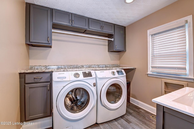 3116 Osprey Rd, Louisville, KY 40213 - laundry room featuring washing machine and dryer, wood finished floors, and cabinet space