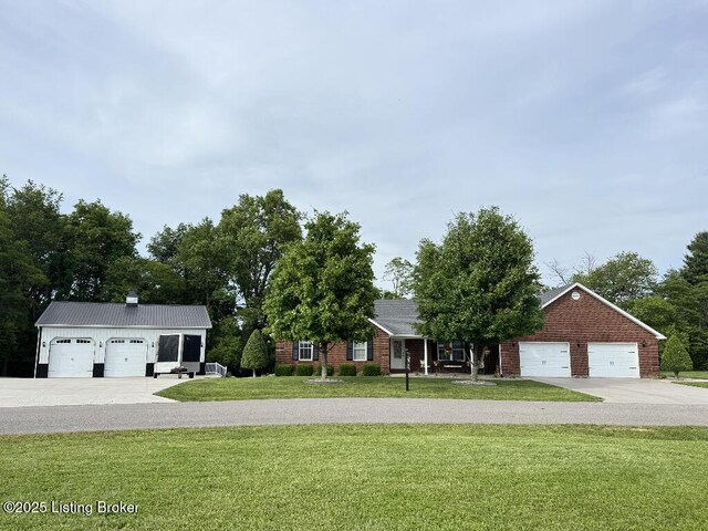 218 Woebegona Way, Hodgenville, KY 42748 - view of front facade with a front lawn, driveway, an attached garage, and brick siding