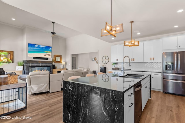 6299 Clore Ln, Crestwood, KY 40014 - kitchen featuring appliances with stainless steel finishes, light wood-style floors, crown molding, decorative backsplash, and an island with sink