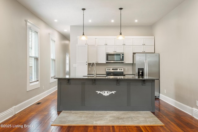 948 Samuel St, Louisville, KY 40204 - kitchen with stainless steel appliances, dark stone counters, dark wood-style floors, a breakfast bar, and recessed lighting