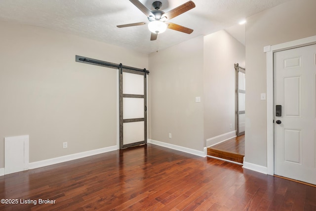 948 Samuel St, Louisville, KY 40204 - empty room with a barn door, ceiling fan, wood finished floors, and a textured ceiling