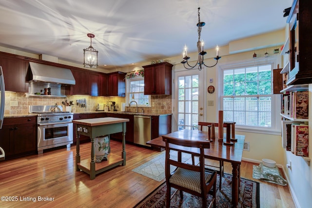 7009 Quail Brace Ct, Louisville, KY 40241 - kitchen with exhaust hood, appliances with stainless steel finishes, a chandelier, light countertops, and decorative backsplash