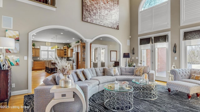 8705 Summit Ridge Dr, Louisville, KY 40241 - living area with a high ceiling, healthy amount of natural light, arched walkways, light wood-style flooring, and decorative columns