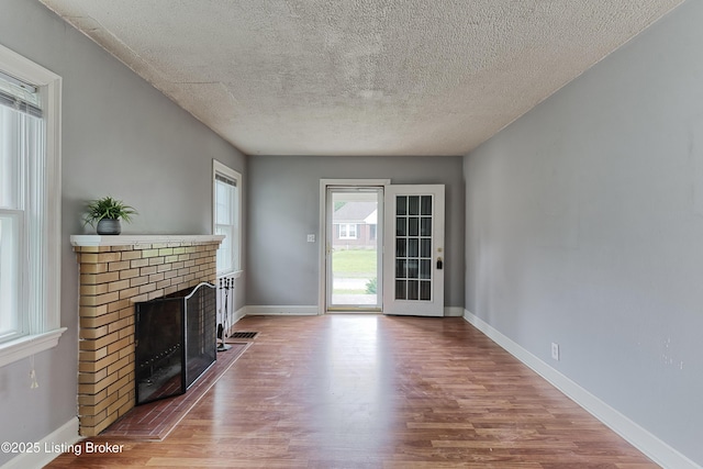 3019 Wirth Ave, Louisville, KY 40217 - unfurnished living room with wood finished floors, a fireplace, and a textured ceiling