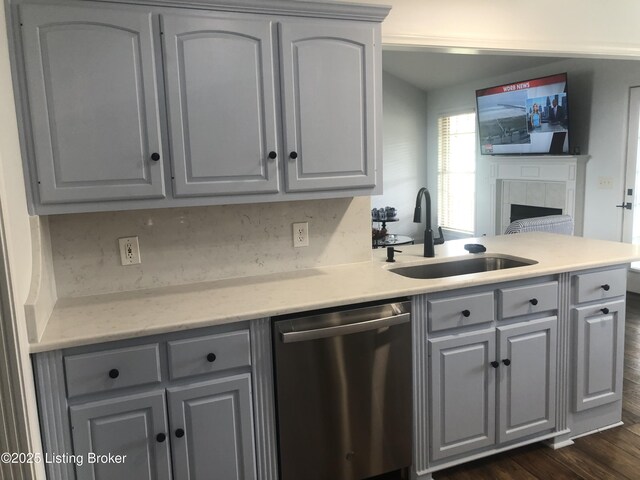 149 Wood Gate Dr, Mt Washington, KY 40047 - kitchen with stainless steel dishwasher, gray cabinets, a tile fireplace, dark wood finished floors, and a peninsula