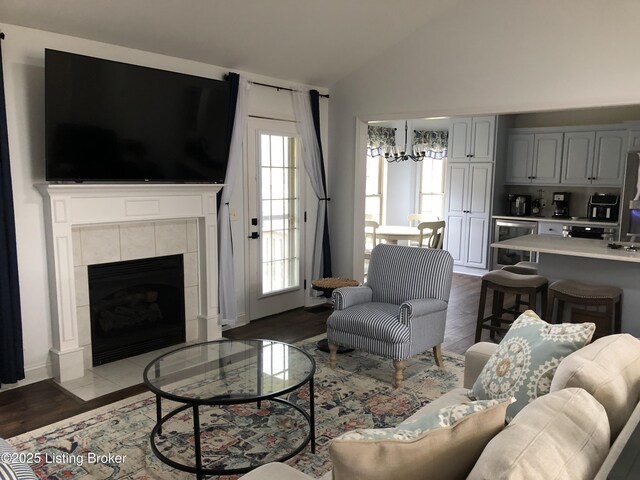 149 Wood Gate Dr, Mt Washington, KY 40047 - living area with a chandelier, lofted ceiling, dark wood-style flooring, a tiled fireplace, and wine cooler