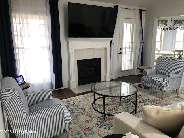 149 Wood Gate Dr, Mt Washington, KY 40047 - living area featuring a chandelier, healthy amount of natural light, a tiled fireplace, and wood finished floors