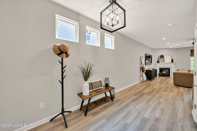 19136 Catalpa Fields Pl, Louisville, KY 40023 - living area with a chandelier, light wood-style flooring, recessed lighting, and a glass covered fireplace