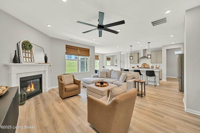 19136 Catalpa Fields Pl, Louisville, KY 40023 - living room featuring ceiling fan, a glass covered fireplace, light wood-type flooring, and recessed lighting