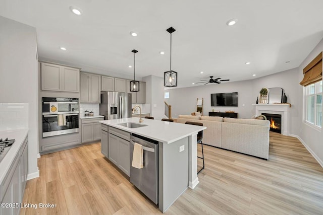 19136 Catalpa Fields Pl, Louisville, KY 40023 - kitchen with gray cabinetry, stainless steel appliances, ceiling fan, light wood-style flooring, and recessed lighting