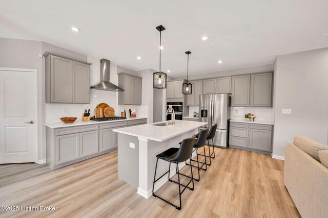 19136 Catalpa Fields Pl, Louisville, KY 40023 - kitchen with gray cabinets, wall chimney exhaust hood, stainless steel fridge, gas stovetop, and a breakfast bar area