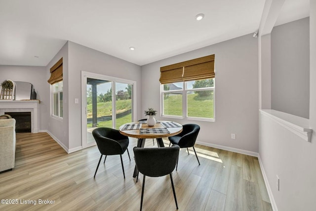 19136 Catalpa Fields Pl, Louisville, KY 40023 - dining room with light wood-type flooring, a glass covered fireplace, and recessed lighting