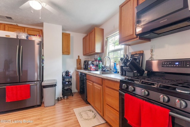 703 Cheri Way, Fairdale, KY 40118 - kitchen with appliances with stainless steel finishes, light countertops, light wood-type flooring, brown cabinetry, and ceiling fan