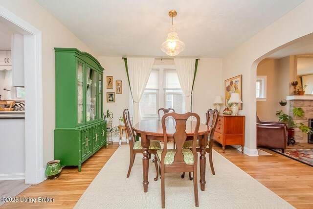 114 S Crestmoor Ave, Louisville, KY 40206 - dining area featuring light wood-style flooring, arched walkways, and healthy amount of natural light