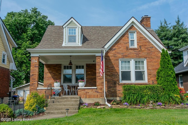 114 S Crestmoor Ave, Louisville, KY 40206 - view of front of property featuring a porch, a chimney, brick siding, a front yard, and a shingled roof