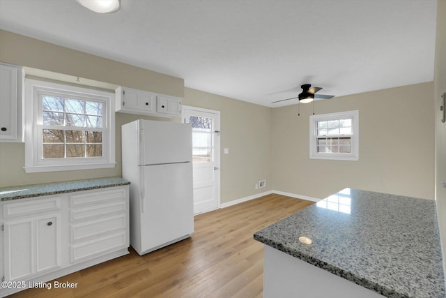 1123 Meadowridge Trl, Goshen, KY 40026 - kitchen featuring freestanding refrigerator, white cabinetry, light wood-style flooring, ceiling fan, and light stone counters