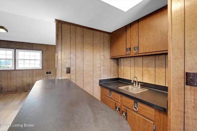 1123 Meadowridge Trl, Goshen, KY 40026 - kitchen featuring brown cabinetry, dark countertops, wood finished floors, and wood walls