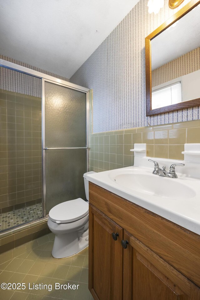 6704 Hollow Tree Rd, Louisville, KY 40228 - full bathroom with wallpapered walls, vanity, a shower stall, tile walls, and tile patterned floors
