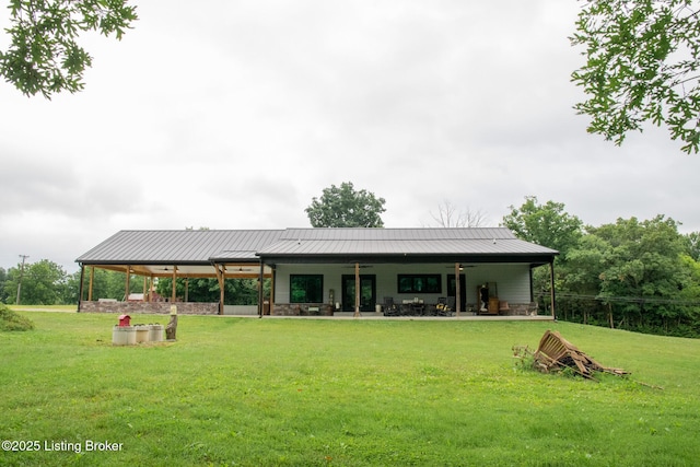 9115 Independence School Rd, Louisville, KY 40228 - rear view of property featuring a lawn, a patio, stone siding, and a metal roof