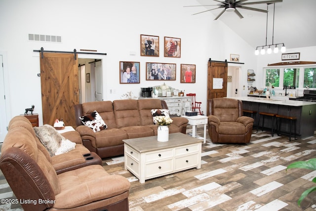 9115 Independence School Rd, Louisville, KY 40228 - living room with a barn door, high vaulted ceiling, a ceiling fan, and light wood-type flooring