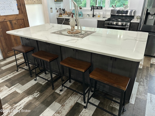 9115 Independence School Rd, Louisville, KY 40228 - kitchen featuring stainless steel appliances, wood finished floors, light stone countertops, and a large island