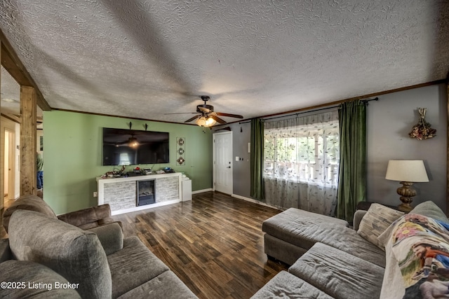 94 Buckhorn Ln, Leitchfield, KY 42754 - living room featuring a ceiling fan, dark wood finished floors, a fireplace, crown molding, and a textured ceiling