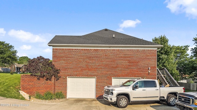 131 Benelli Dr, Bardstown, KY 40004 - view of home's exterior featuring an attached garage, roof with shingles, driveway, brick siding, and stairway