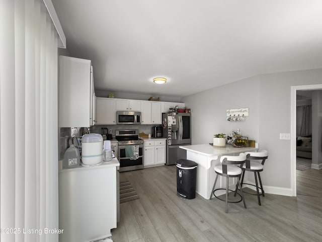 131 Benelli Dr, Bardstown, KY 40004 - kitchen with stainless steel appliances, light countertops, light wood finished floors, and a kitchen bar