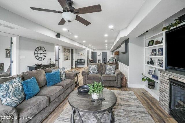 57 Pilots Way, Taylorsville, KY 40071 - living room with wood finished floors, a ceiling fan, a stone fireplace, recessed lighting, and built in features