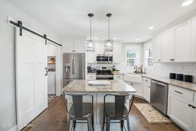 57 Pilots Way, Taylorsville, KY 40071 - kitchen with appliances with stainless steel finishes, a barn door, dark wood-style floors, a kitchen bar, and white cabinets
