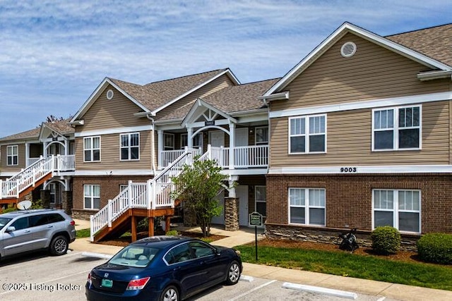 9003 Falcon Crest Ct Unit 104, Louisville, KY 40219 - townhome / multi-family property with stairs, uncovered parking, covered porch, and brick siding