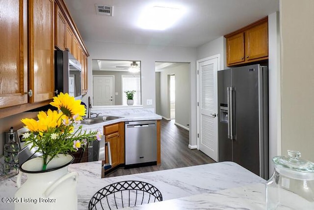 9003 Falcon Crest Ct Unit 104, Louisville, KY 40219 - kitchen with appliances with stainless steel finishes, brown cabinetry, dark wood-type flooring, and ceiling fan
