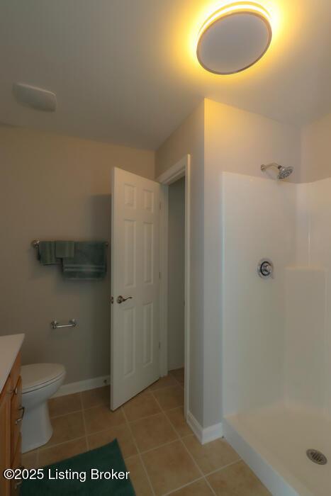 9003 Falcon Crest Ct Unit 104, Louisville, KY 40219 - bathroom with vanity, tile patterned floors, and a shower