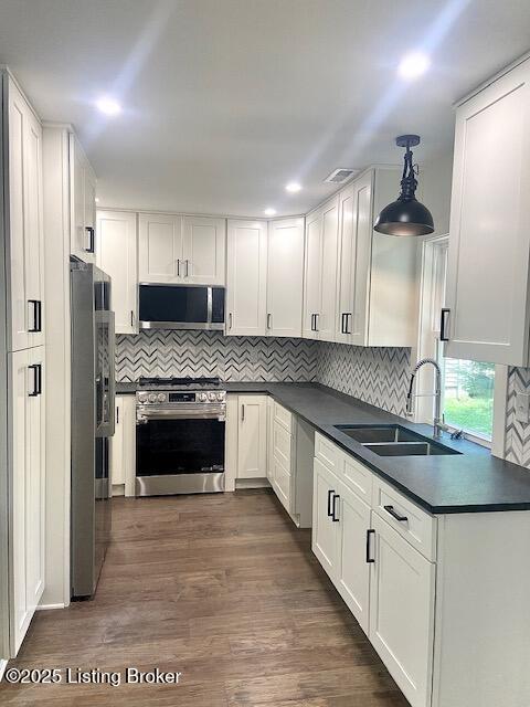 1711 Washington Blvd, Lyndon, KY 40242 - kitchen featuring stainless steel appliances, dark countertops, white cabinetry, dark wood finished floors, and backsplash