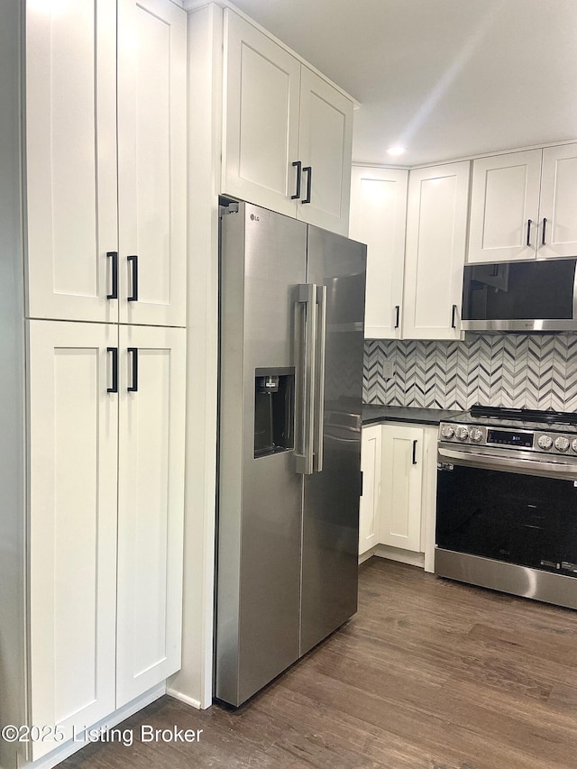 1711 Washington Blvd, Lyndon, KY 40242 - kitchen with appliances with stainless steel finishes, white cabinets, dark countertops, tasteful backsplash, and dark wood finished floors