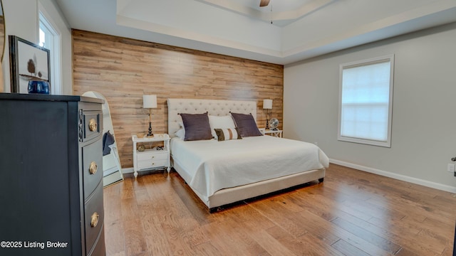 116 N Howard St, Bardstown, KY 40004 - bedroom featuring wood walls, wood finished floors, a ceiling fan, and a raised ceiling