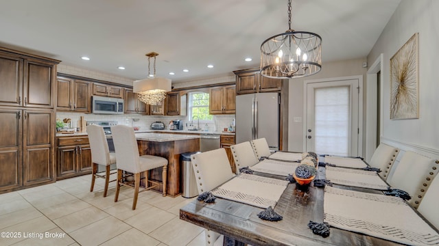 116 N Howard St, Bardstown, KY 40004 - kitchen featuring appliances with stainless steel finishes, a chandelier, a center island, a kitchen bar, and tasteful backsplash