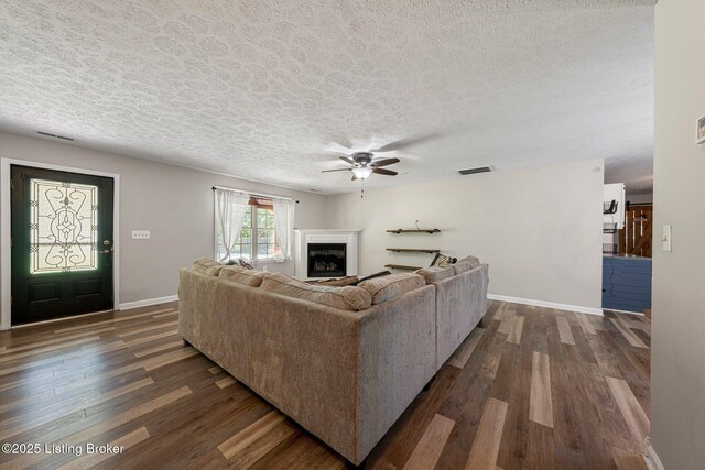 606 Lone Oak Rd, Clarkson, KY 42726 - living area with dark wood-style flooring, a ceiling fan, a fireplace, and a textured ceiling
