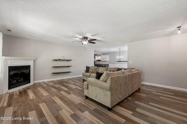 606 Lone Oak Rd, Clarkson, KY 42726 - living room featuring ceiling fan, wood finished floors, a fireplace, a chandelier, and a textured ceiling
