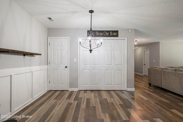606 Lone Oak Rd, Clarkson, KY 42726 - unfurnished dining area featuring wood finished floors, a chandelier, a textured ceiling, and a wainscoted wall