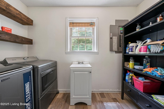 606 Lone Oak Rd, Clarkson, KY 42726 - laundry area featuring washing machine and dryer, electric panel, and wood finished floors