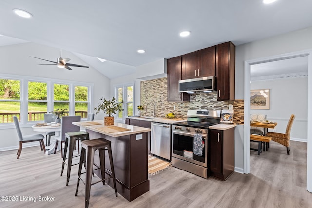 5515 Hempstead Rd, Louisville, KY 40207 - kitchen with stainless steel appliances, light countertops, dark brown cabinetry, decorative backsplash, and light wood-type flooring