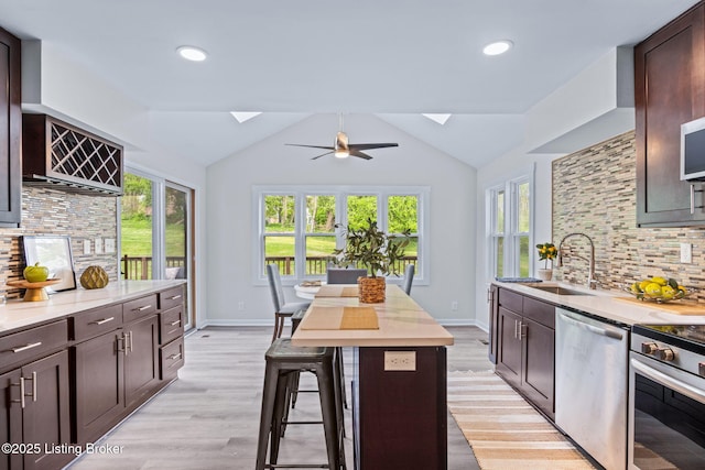 5515 Hempstead Rd, Louisville, KY 40207 - kitchen with appliances with stainless steel finishes, a skylight, tasteful backsplash, dark brown cabinets, and lofted ceiling