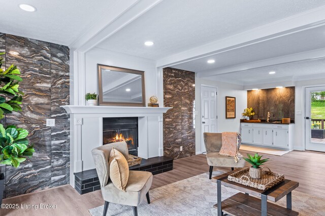 5515 Hempstead Rd, Louisville, KY 40207 - living area featuring light wood-type flooring, beamed ceiling, a lit fireplace, recessed lighting, and bar area