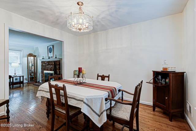 7401 Switch Bark Rd, Louisville, KY 40228 - dining area featuring wood finished floors, a chandelier, and a brick fireplace
