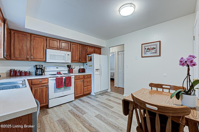 7401 Switch Bark Rd, Louisville, KY 40228 - kitchen with white appliances, light countertops, light wood-type flooring, and brown cabinetry