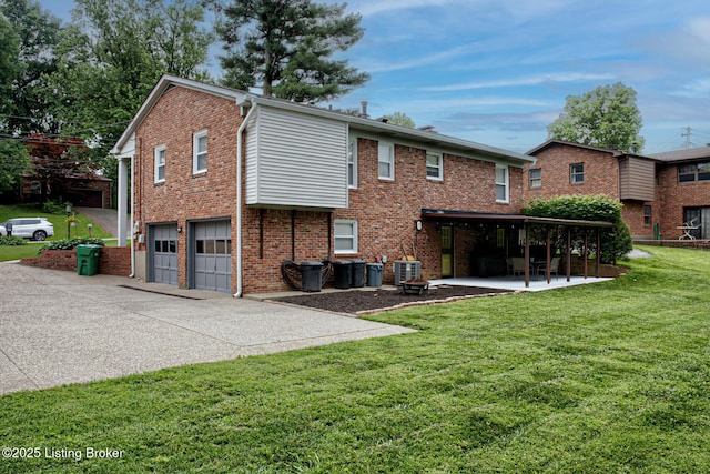7401 Switch Bark Rd, Louisville, KY 40228 - rear view of house featuring a garage, a yard, driveway, a patio area, and brick siding