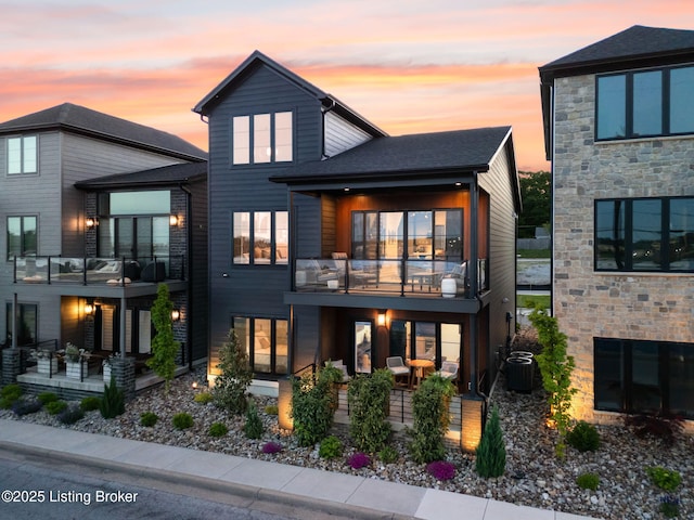 104 Howard Ln, Jeffersonville, IN 47130 - back of property at dusk featuring a balcony, a patio, and stone siding