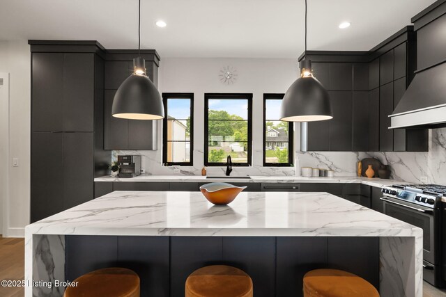 104 Howard Ln, Jeffersonville, IN 47130 - kitchen featuring stainless steel gas range, a breakfast bar, dark cabinetry, decorative backsplash, and recessed lighting