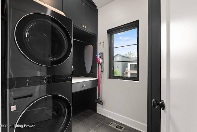 104 Howard Ln, Jeffersonville, IN 47130 - laundry area featuring stacked washing machine and dryer and dark tile patterned flooring
